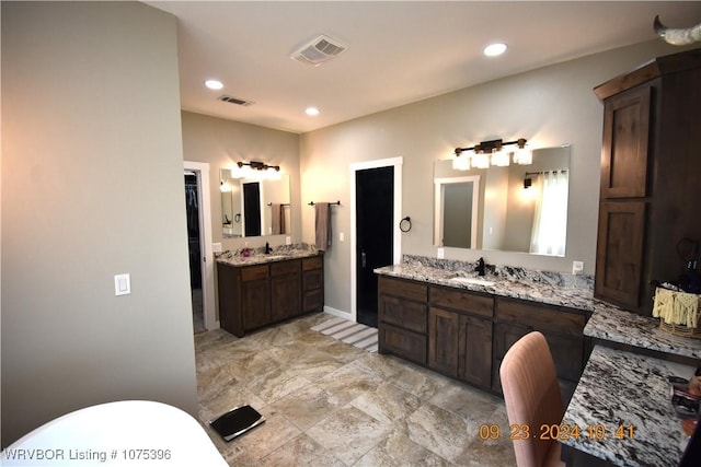 bathroom featuring a washtub and vanity