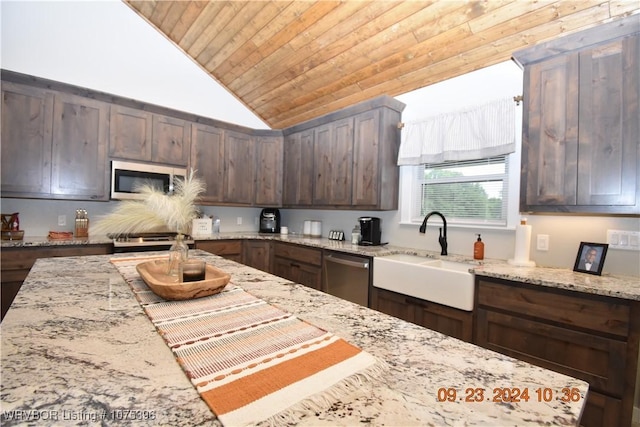 kitchen with light stone counters, sink, lofted ceiling, and appliances with stainless steel finishes