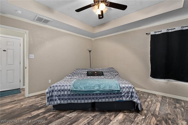 bedroom featuring crown molding, ceiling fan, a tray ceiling, and dark hardwood / wood-style flooring