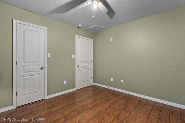 spare room featuring hardwood / wood-style flooring, ceiling fan, and a textured ceiling