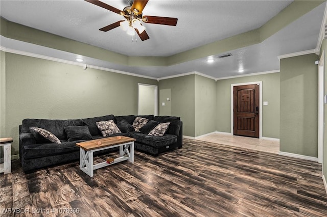 living room featuring crown molding, hardwood / wood-style flooring, a raised ceiling, and ceiling fan