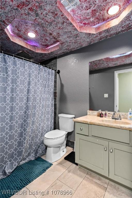 bathroom featuring a shower with curtain, vanity, tile patterned floors, and toilet