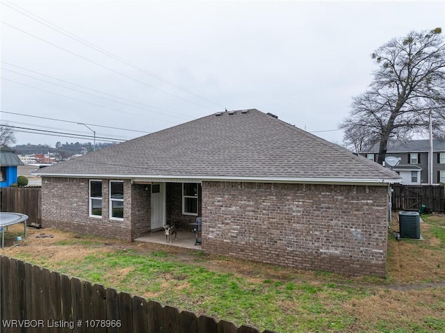 back of property with a patio, a yard, a trampoline, and central air condition unit