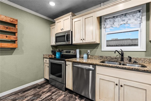 kitchen with sink, dark stone countertops, dark hardwood / wood-style flooring, stainless steel appliances, and crown molding