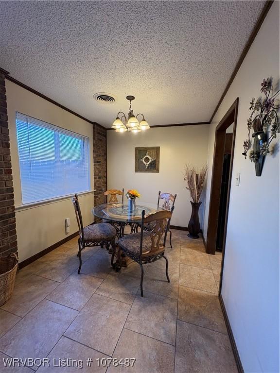 dining room with ornamental molding, an inviting chandelier, and a textured ceiling