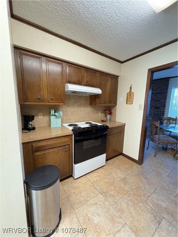 kitchen with ornamental molding, electric range, a textured ceiling, and decorative backsplash