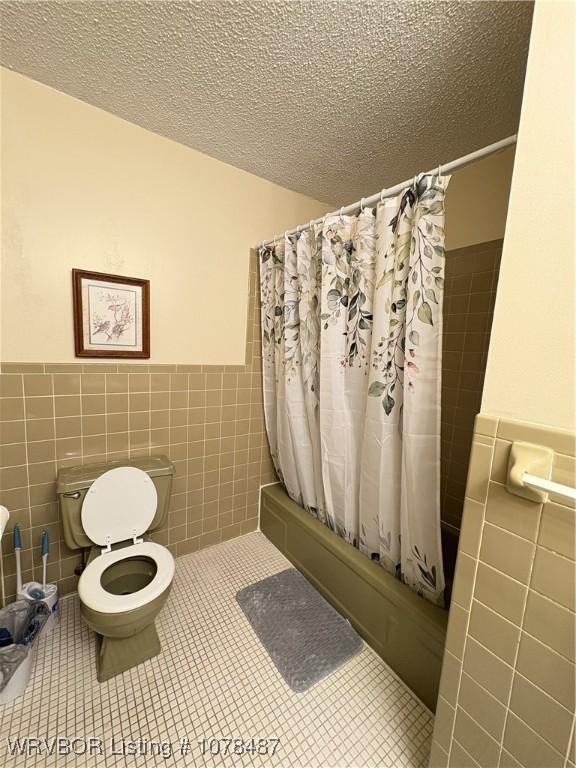 bathroom featuring tile patterned floors, a textured ceiling, and shower / bath combo