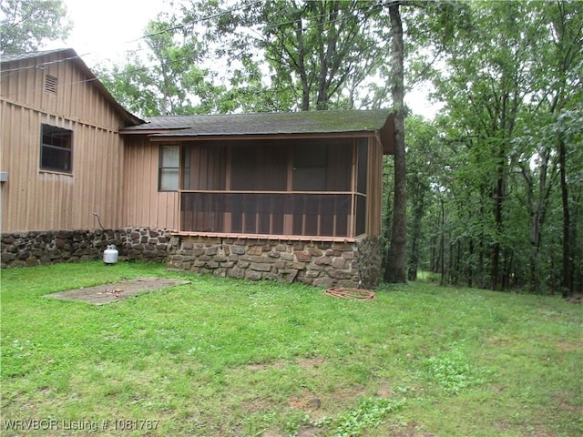 15632 Pink Twist Rd, Ozark, AR 72949 - view of front facade featuring a sunroom, a front lawn, stone siding, and roof with shingles