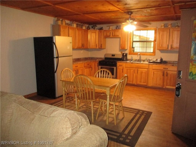 15632 Pink Twist Rd, Ozark, AR 72949 - kitchen featuring stainless steel appliances, ceiling fan, light wood-style flooring, wallpapered walls, and dark countertops
