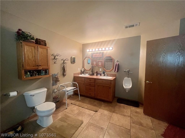 bathroom featuring tile patterned flooring, vanity, and toilet