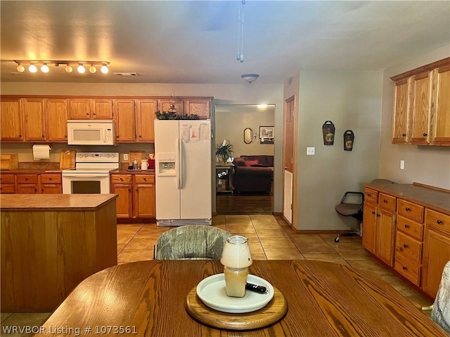 kitchen featuring light tile patterned floors and white appliances