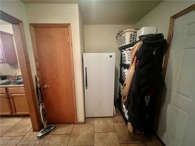 laundry area with sink and light tile patterned floors