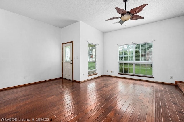spare room featuring baseboards, wood finished floors, ceiling fan, and a textured ceiling