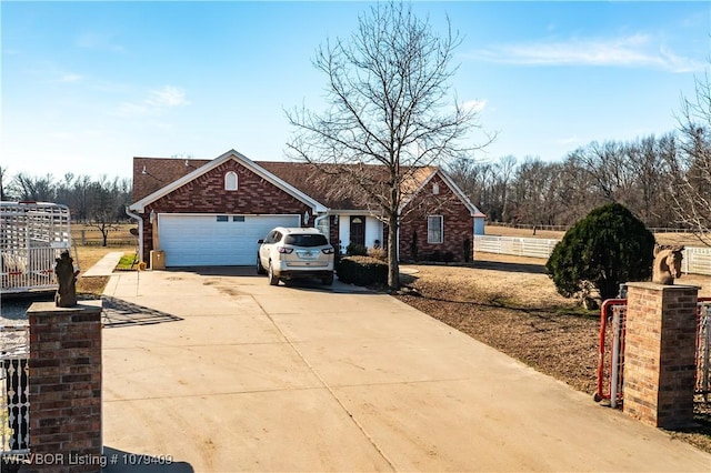 view of front of property featuring an attached garage, fence, concrete driveway, and brick siding