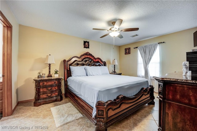 bedroom with visible vents, ceiling fan, a textured ceiling, and light tile patterned floors