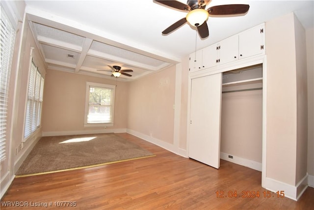 unfurnished bedroom with beam ceiling, ceiling fan, light hardwood / wood-style flooring, and coffered ceiling