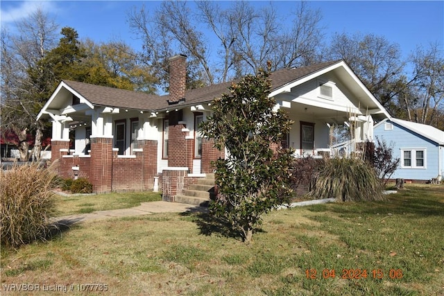 view of front of home with a porch and a front yard