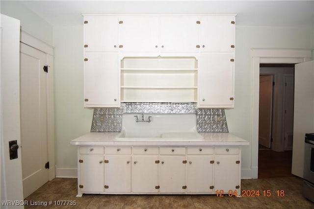 kitchen featuring white cabinetry, decorative backsplash, sink, and stove