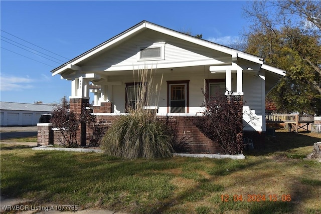 bungalow with a porch and a front lawn