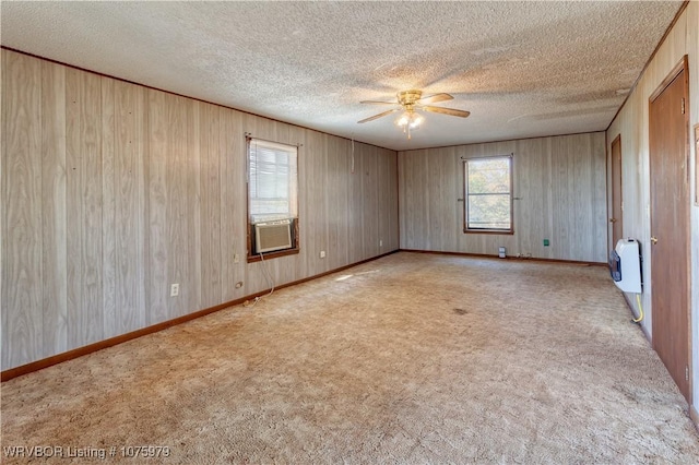 carpeted empty room featuring heating unit, ceiling fan, cooling unit, and a healthy amount of sunlight