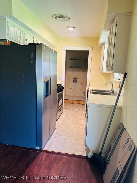 1301 9th St, Barling, AR 72923 - kitchen with a sink, stainless steel appliances, light countertops, and light wood-style flooring