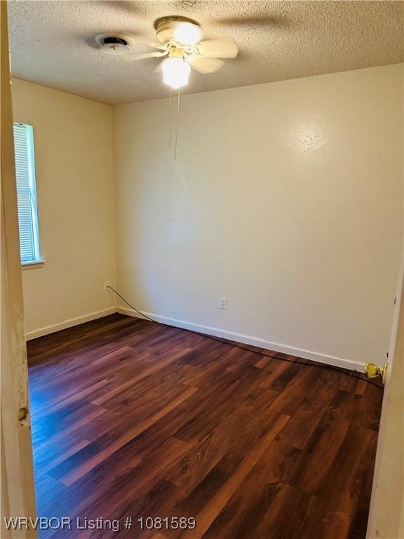 1301 9th St, Barling, AR 72923 - unfurnished room featuring dark wood-style floors, a textured ceiling, a ceiling fan, and baseboards
