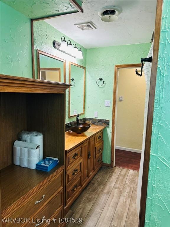 1301 9th St, Barling, AR 72923 - bathroom featuring vanity, wood finished floors, and a textured wall