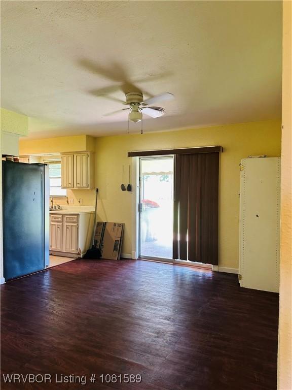 1301 9th St, Barling, AR 72923 - unfurnished living room with wood finished floors, ceiling fan, and baseboards