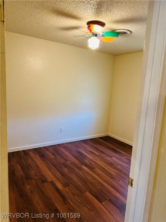 1301 9th St, Barling, AR 72923 - spare room featuring dark wood-style floors, a ceiling fan, a textured ceiling, and baseboards