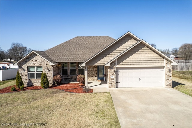 view of front of house with a front yard, fence, roof with shingles, an attached garage, and concrete driveway