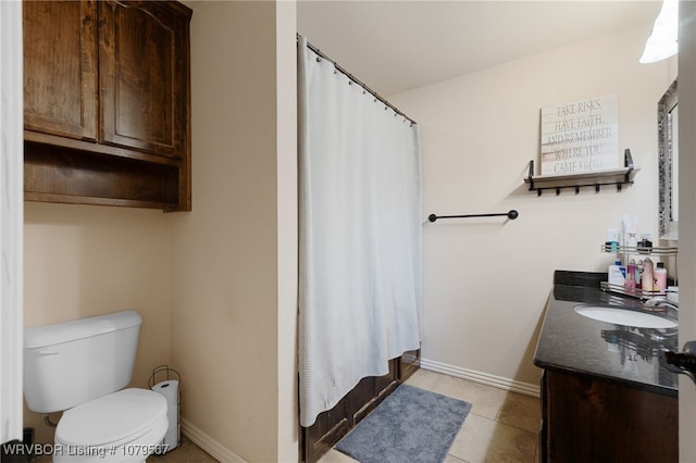 bathroom featuring tile patterned flooring, toilet, vanity, and baseboards