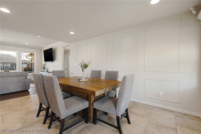 dining area featuring a decorative wall, light tile patterned flooring, and recessed lighting