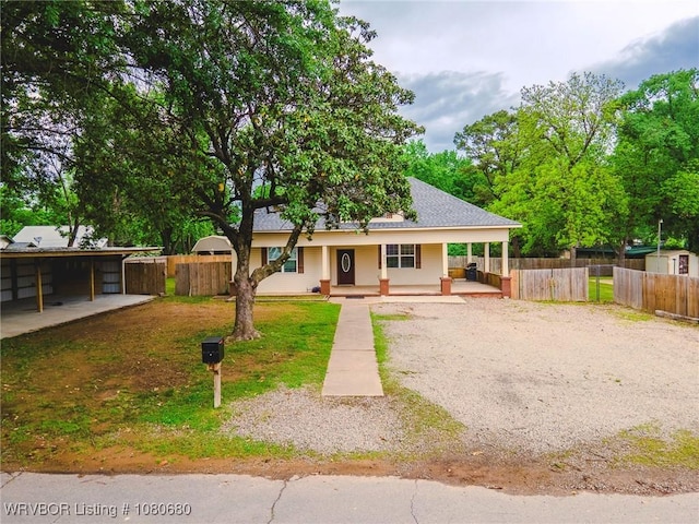 country-style home featuring a porch, fence, and gravel driveway