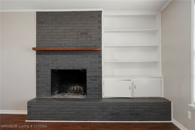 details featuring hardwood / wood-style flooring, ornamental molding, and a brick fireplace