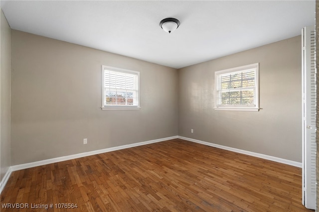 unfurnished room featuring plenty of natural light and wood-type flooring