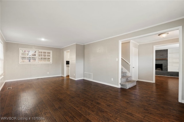 spare room with dark hardwood / wood-style flooring, ornamental molding, and a fireplace