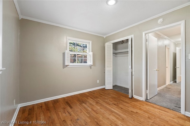 unfurnished bedroom featuring a closet, ornamental molding, and light hardwood / wood-style flooring