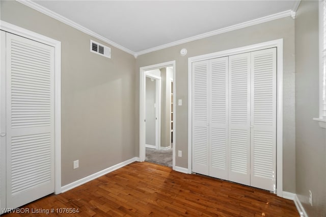 unfurnished bedroom with crown molding and hardwood / wood-style flooring