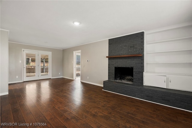 unfurnished living room with ornamental molding, dark wood-type flooring, and a brick fireplace