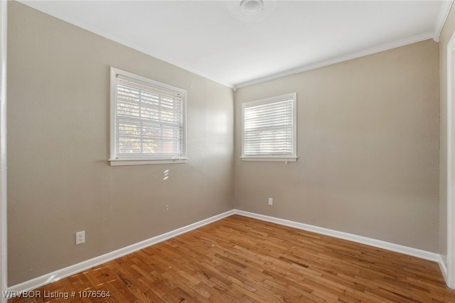 unfurnished room featuring hardwood / wood-style floors, a healthy amount of sunlight, and ornamental molding