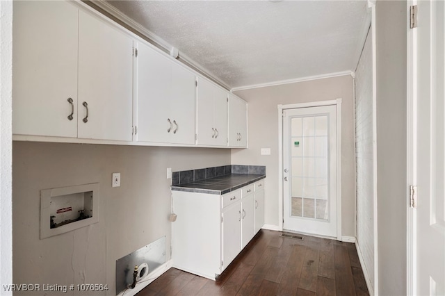 clothes washing area with cabinets, hookup for a washing machine, a textured ceiling, crown molding, and dark hardwood / wood-style floors