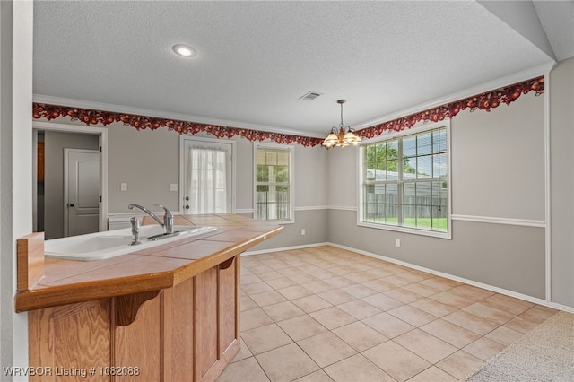 2419 Shealei Cir, Alma, AR 72921 - kitchen featuring tile countertops, a textured ceiling, a chandelier, light tile patterned floors, and decorative light fixtures