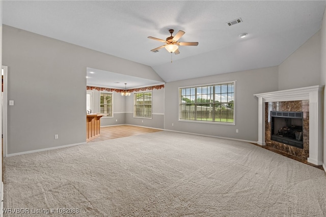 2419 Shealei Cir, Alma, AR 72921 - unfurnished living room featuring carpet flooring, ceiling fan, a premium fireplace, lofted ceiling, and a chandelier
