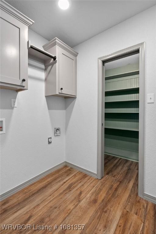2510 Main St, Charleston, AR 72933 - laundry area with wood finished floors, hookup for an electric dryer, washer hookup, baseboards, and cabinet space