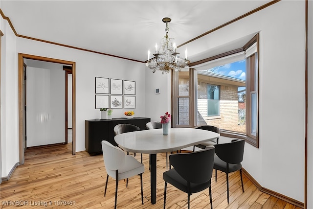 dining area featuring crown molding, light wood-style floors, baseboards, and a chandelier