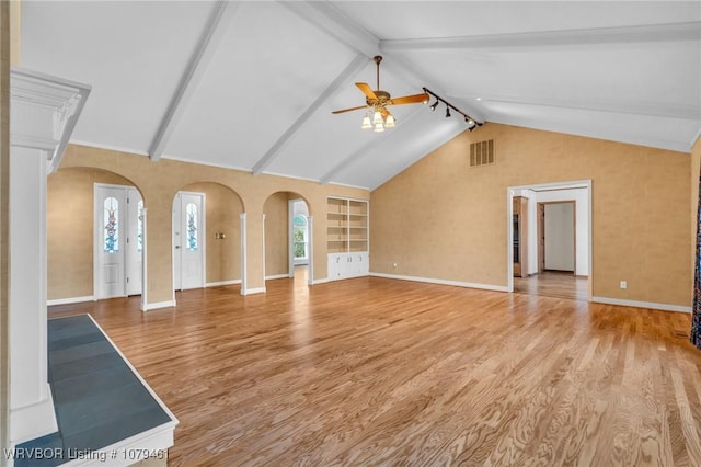 unfurnished living room with arched walkways, visible vents, ceiling fan, and wood finished floors