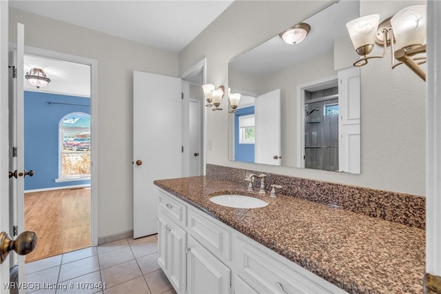 bathroom with tile patterned flooring, walk in shower, vanity, and a wealth of natural light