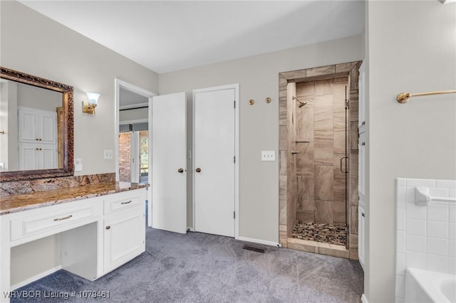 bathroom with visible vents, a shower stall, a washtub, and vanity