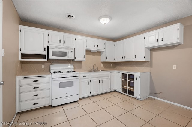 kitchen featuring white cabinetry, sink, white appliances, and decorative backsplash