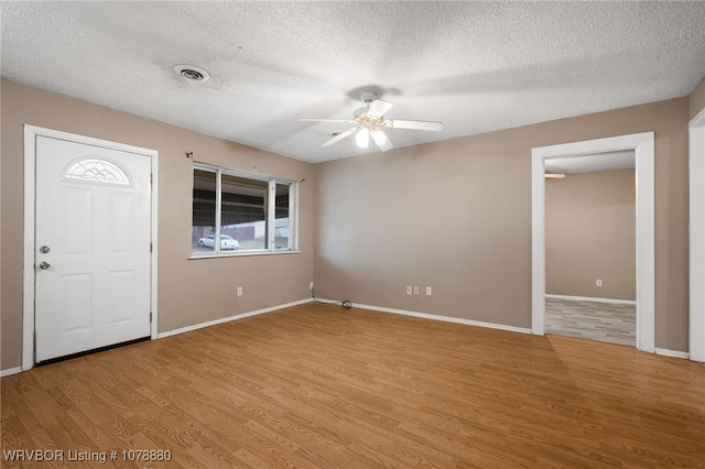 foyer featuring a textured ceiling, ceiling fan, and light wood-type flooring